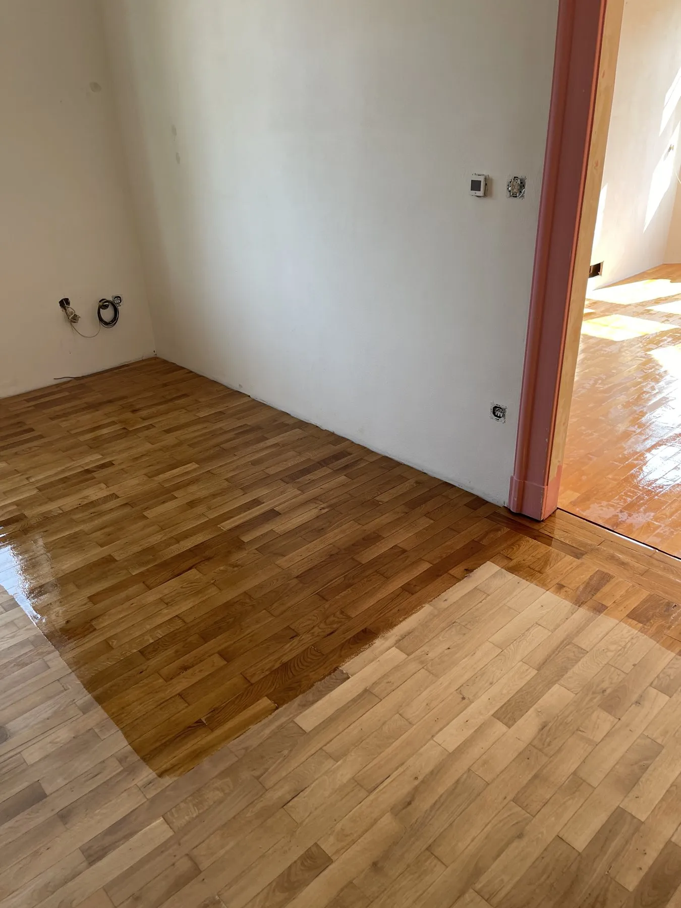Pokoj, kde je polovina podlahy nalakovaná a druhá polovina ještě přebroušená